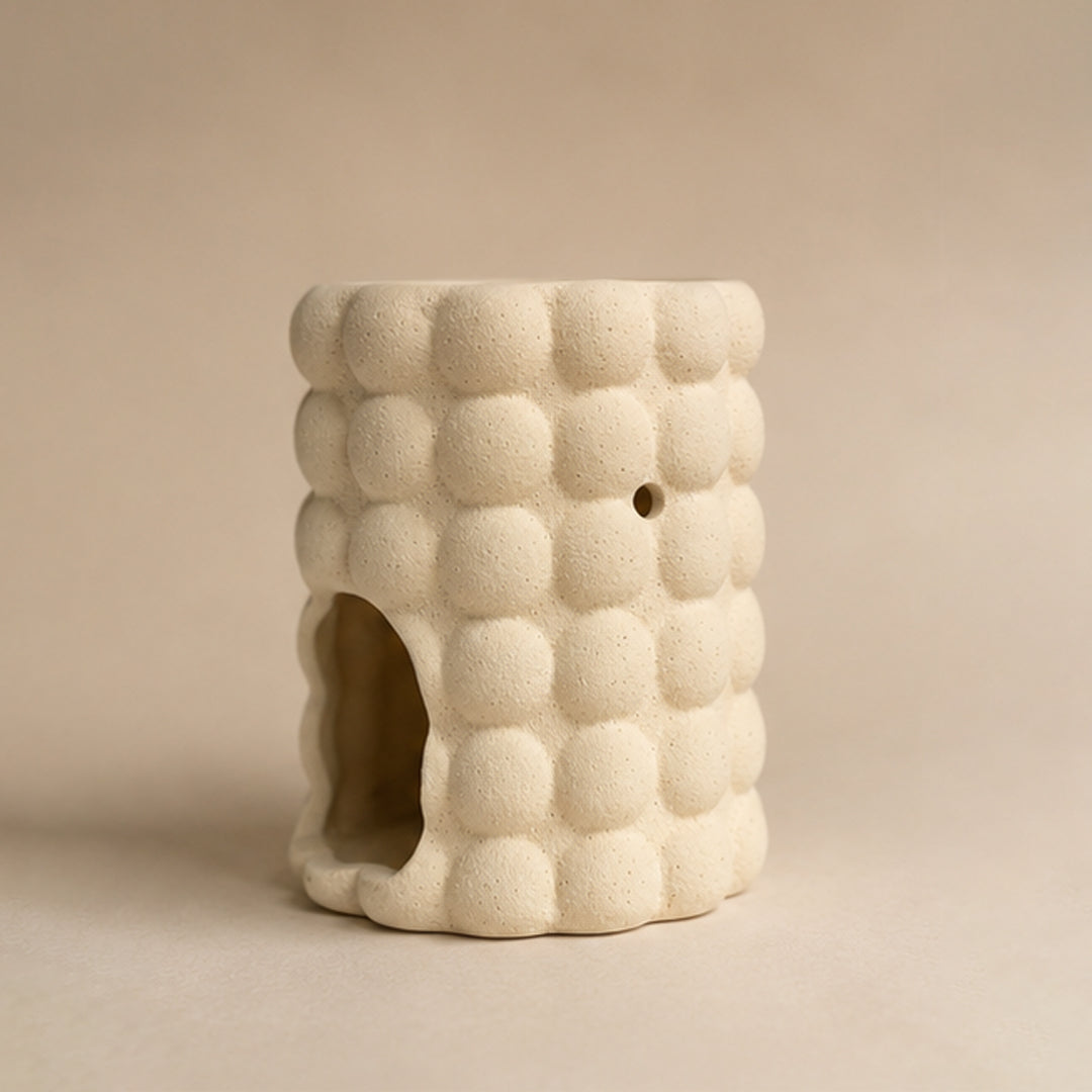 Ceramic textured bubble wax burner on a beige background
