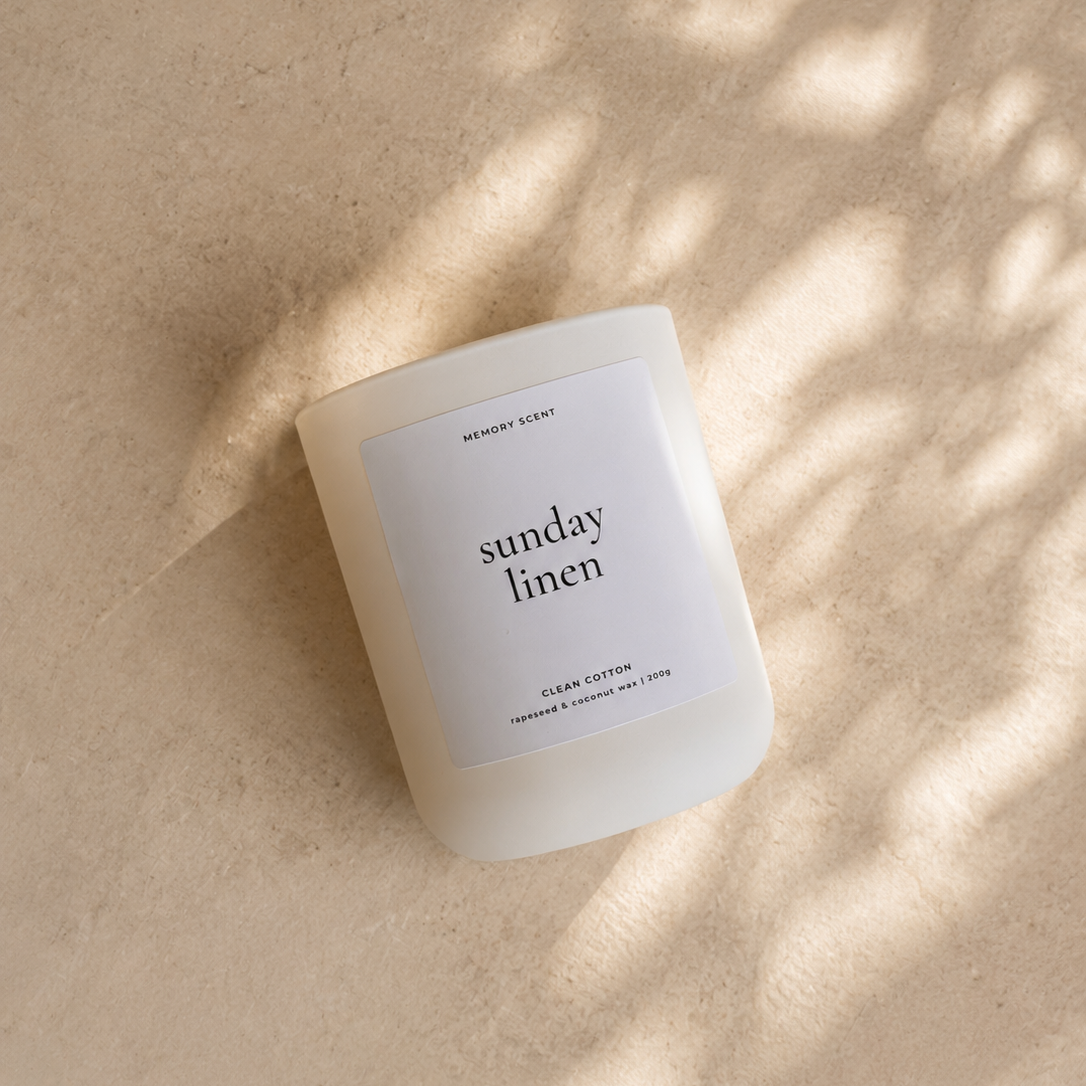 Candle labeled 'sunday linen' on a beige background