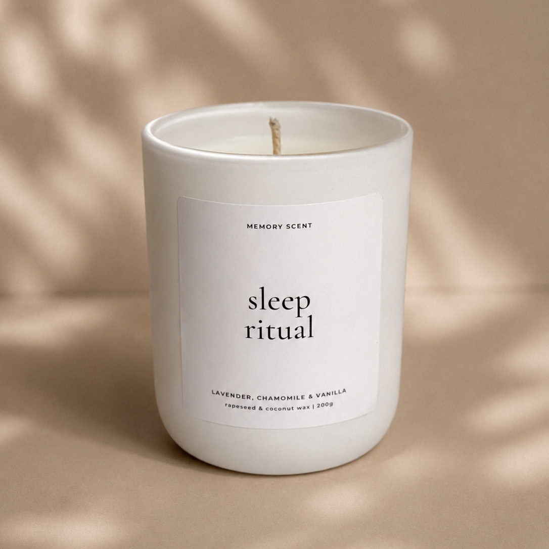 White candle labeled 'sleep ritual' on a beige background with leaf shadows