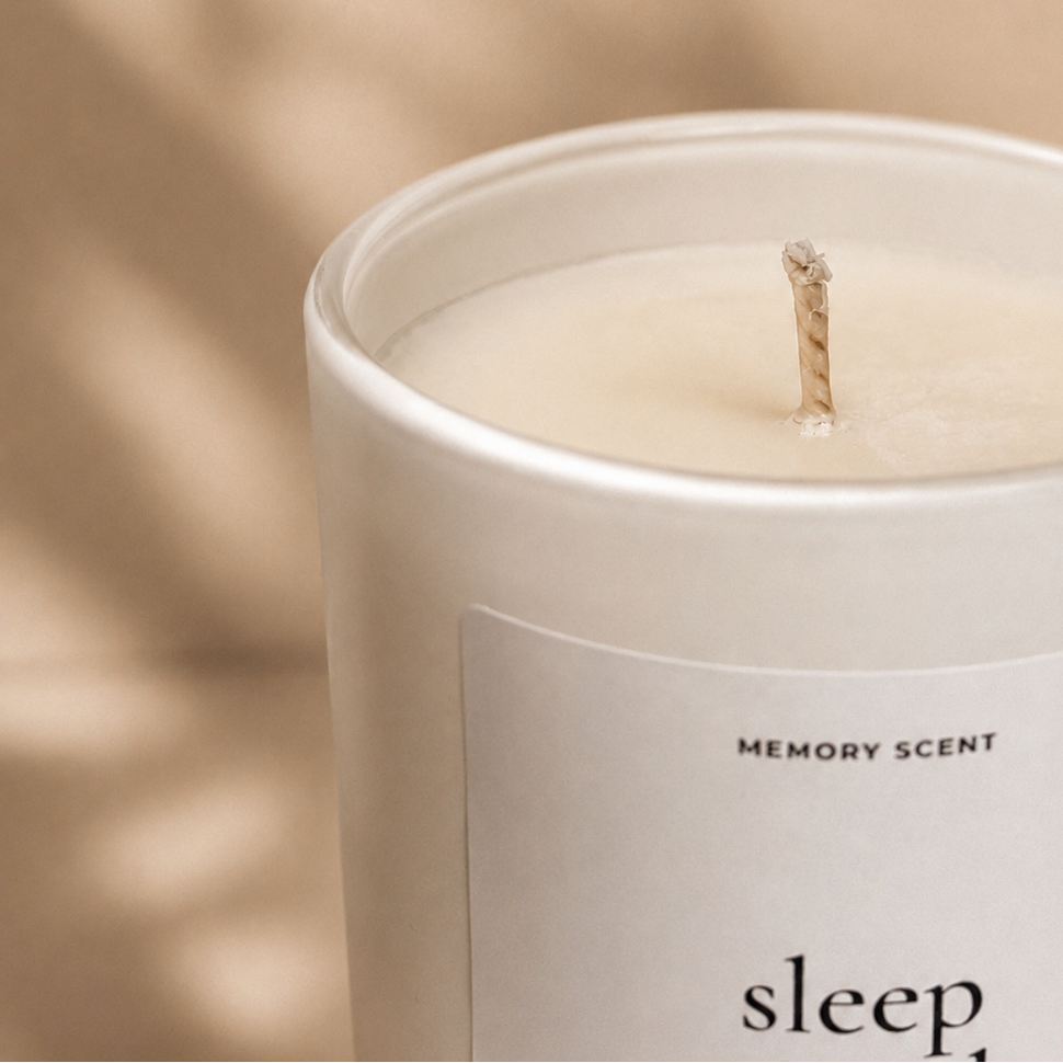 Candle labeled 'sleep' from Memory Scent with a soft focus background