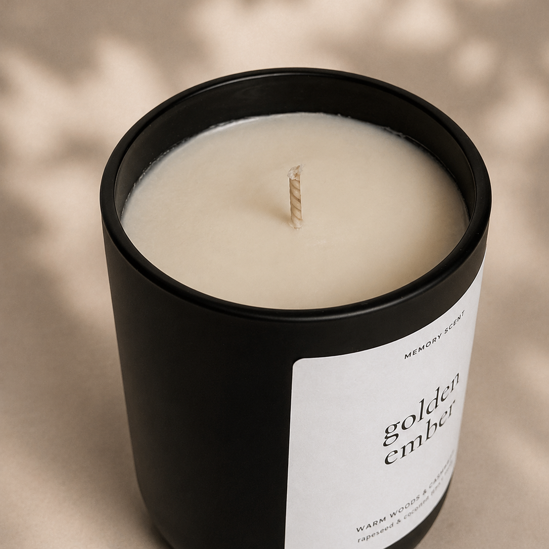 Candle in a black container with a label on a beige background