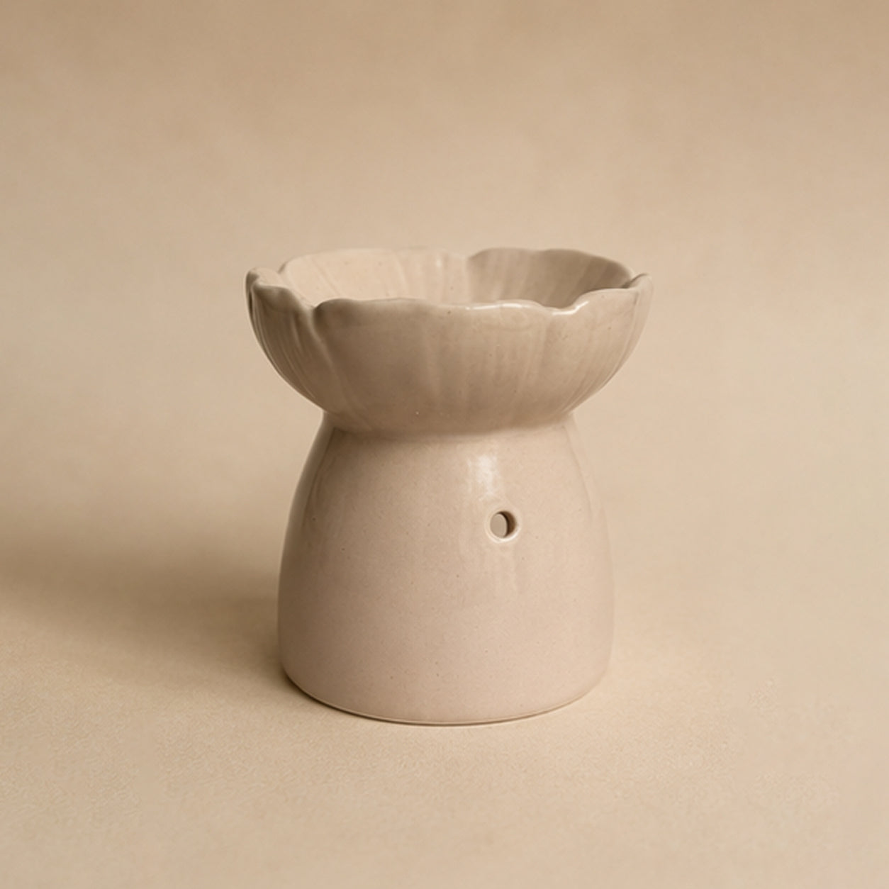 Pink blossom ceramic wax burner front view on a beige plain background.