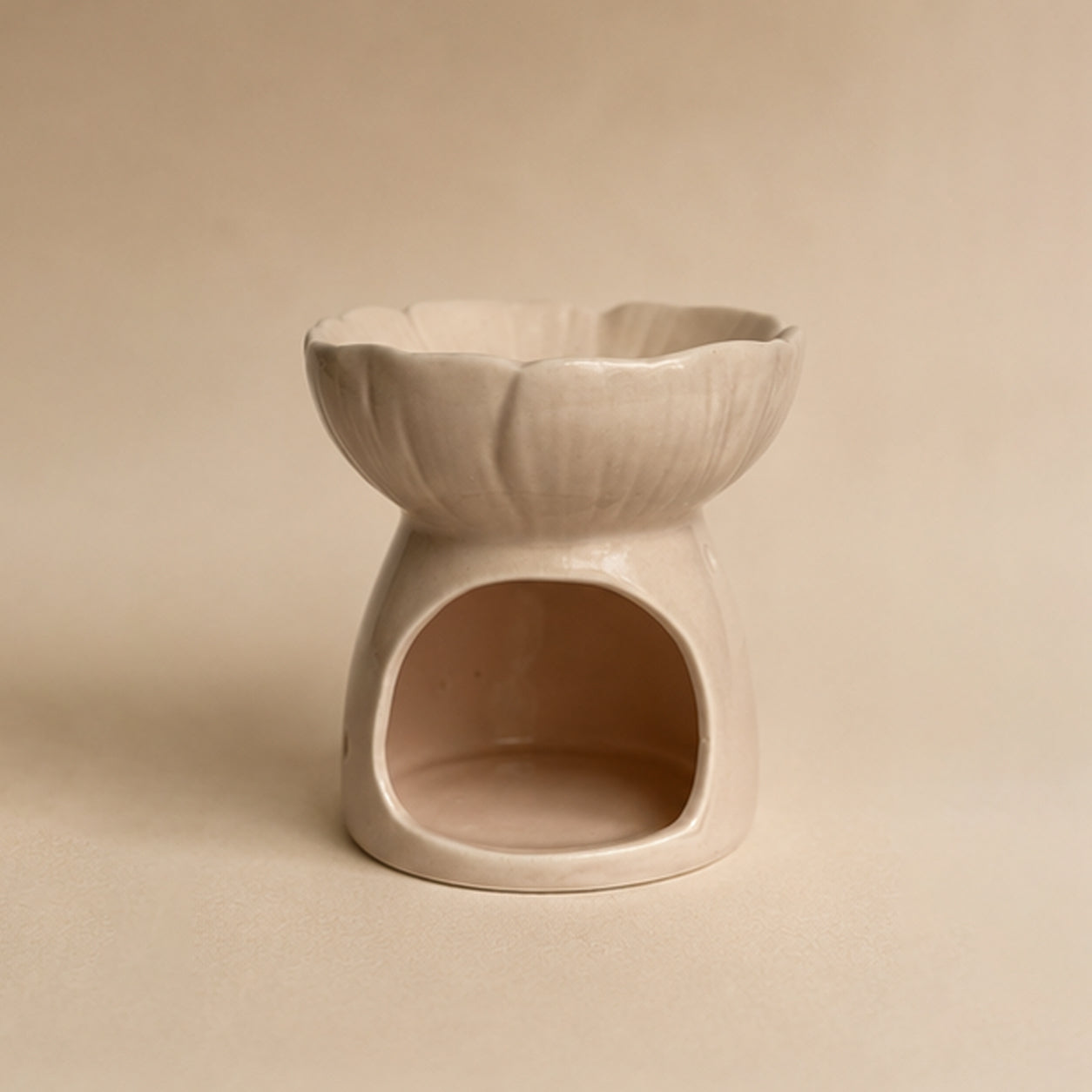 Pink blossom ceramic wax burner back view on a beige plain background.