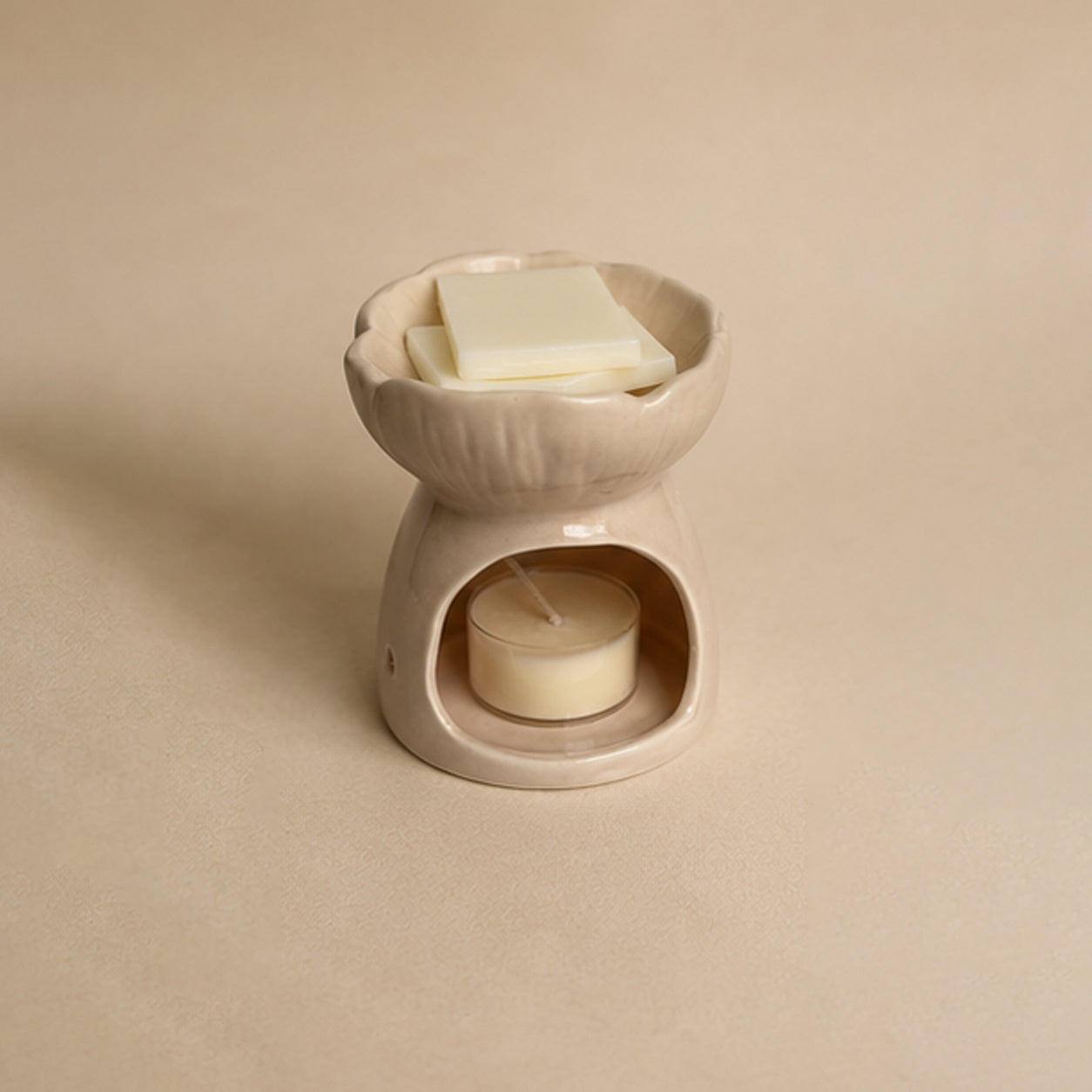 Pink blossom ceramic wax burner back view on a beige plain background, with a tealight unlit inside and wax snap bar blocks in the top.
