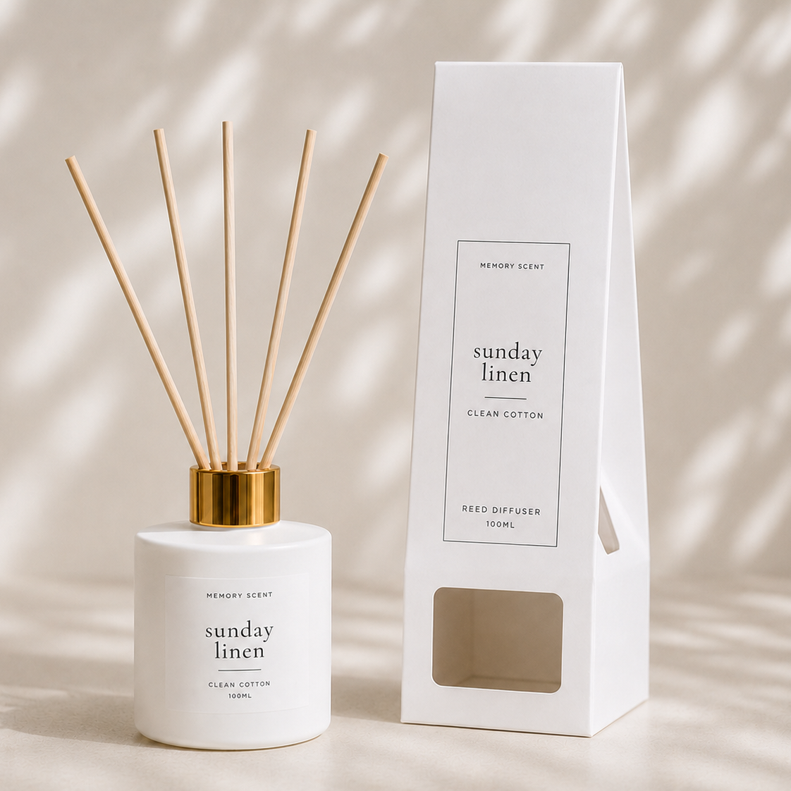 Reed diffuser with gold cap and white container next to its packaging on a neutral background