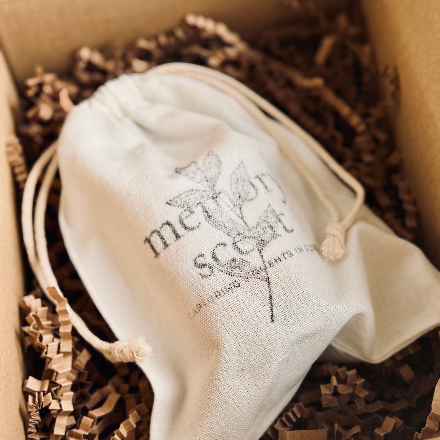 Mother’s Day candle gift packaging in branded 'memory scent' drawstring bag in a box with brown tissue paper 