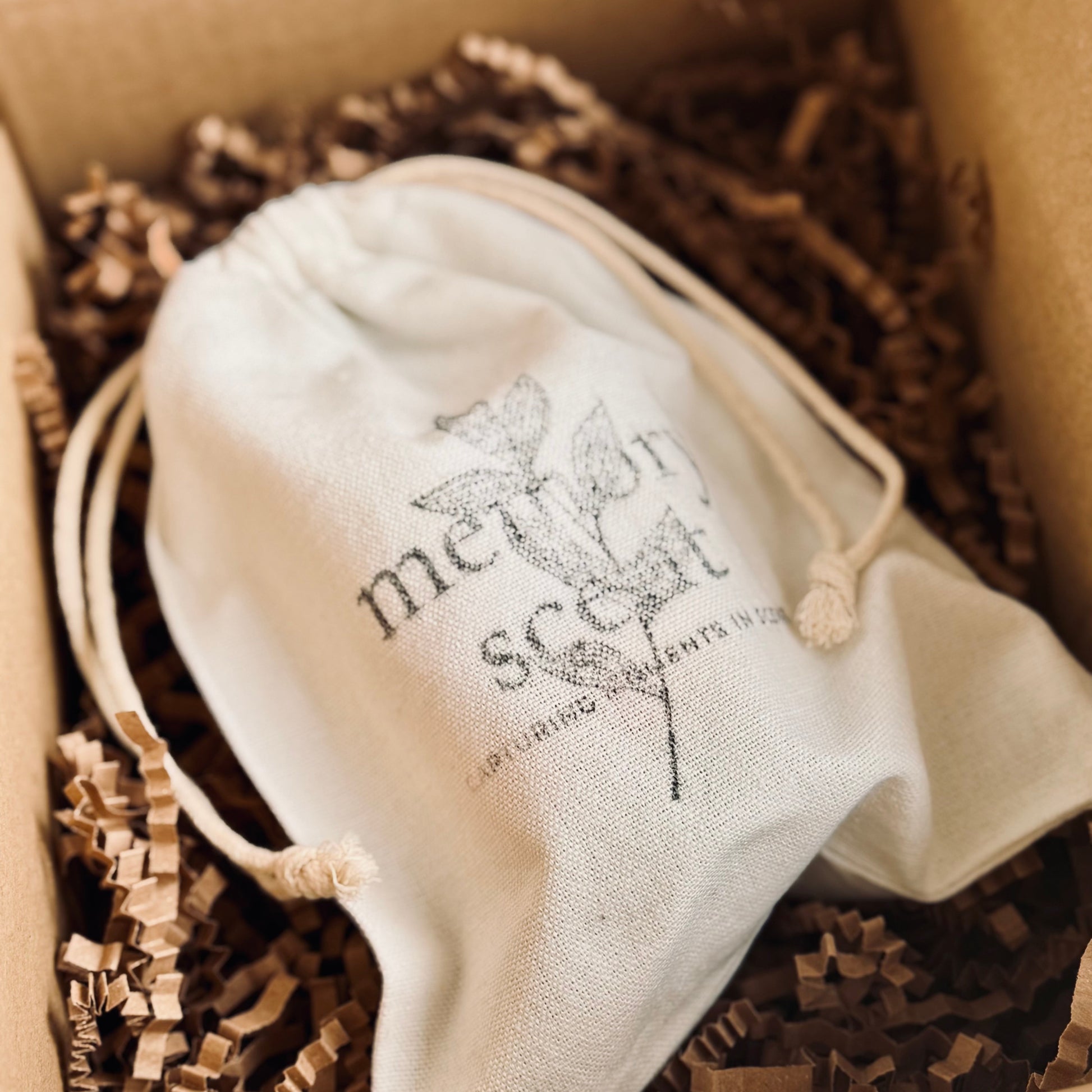 Mother’s Day candle gift packaging in branded 'memory scent' drawstring bag in a box with brown tissue paper 