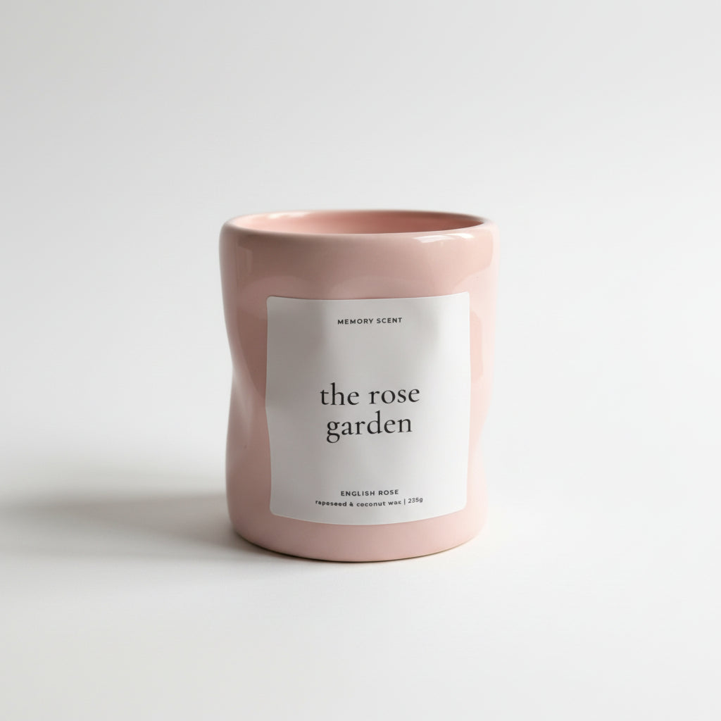 Pink candle labeled 'the rose garden' on a white background